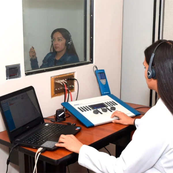 Especialista realizando valoración auditiva en cabina sonoamortiguada